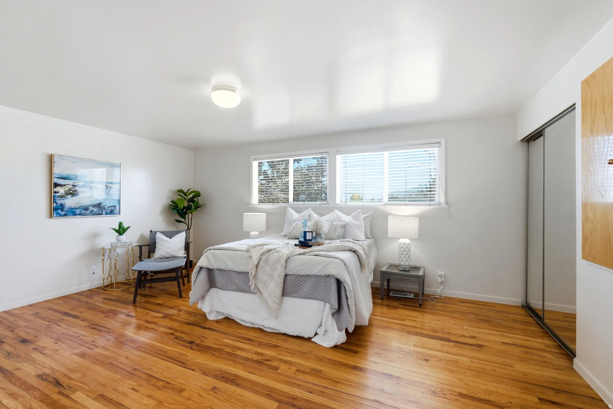 Bright interior space featuring wood-finish flooring, white walls, and a recessed ceiling light