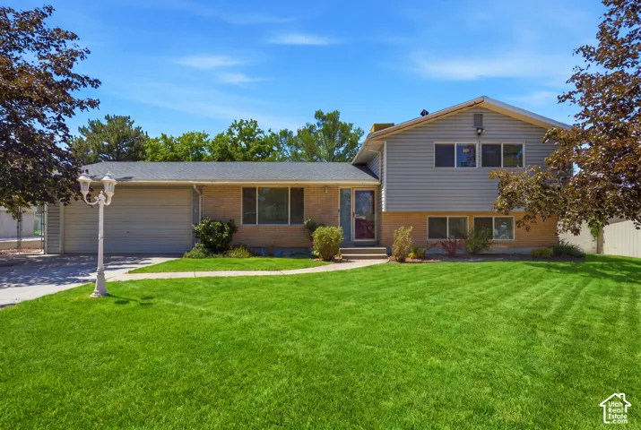 Grass has been virtually enhanced in this image to illustrate the property's outdoor potential. Split-level residence featuring a brick and siding exterior