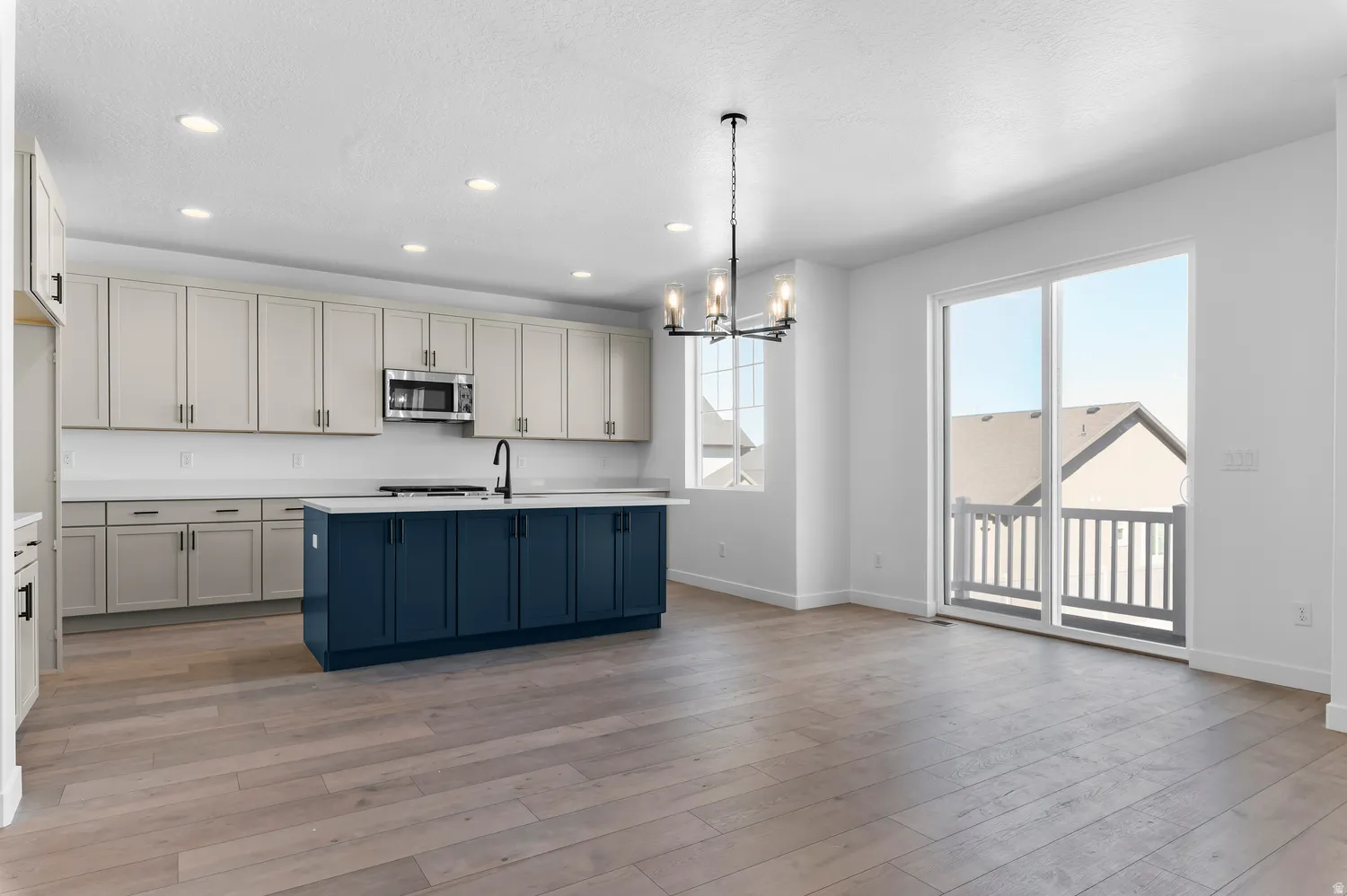 Modern kitchen with two-tone cabinetry, a central island, and wood-finish flooring