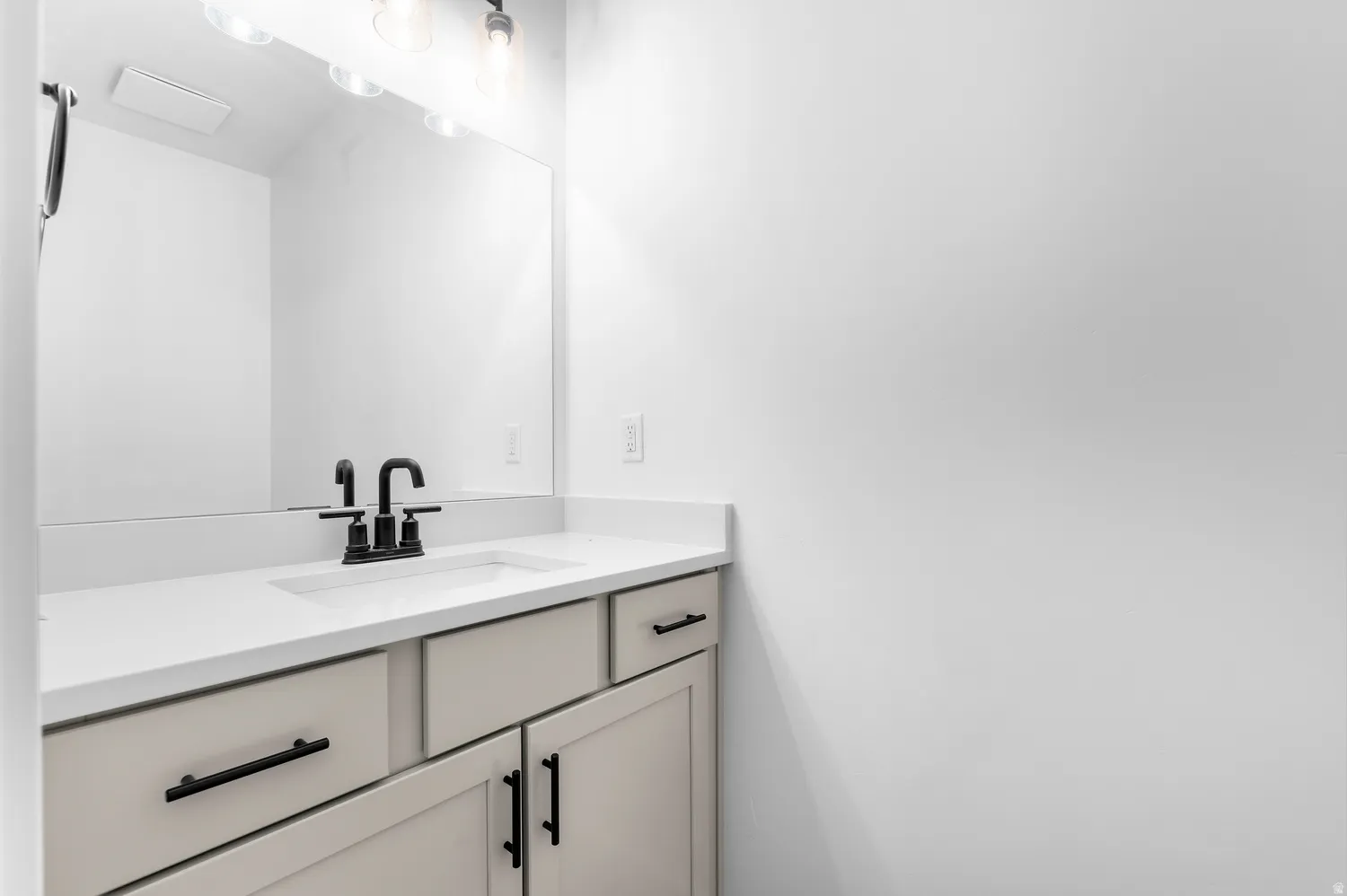 Integrated vanity with a rectangular basin, light-toned countertop, and matte black faucet
