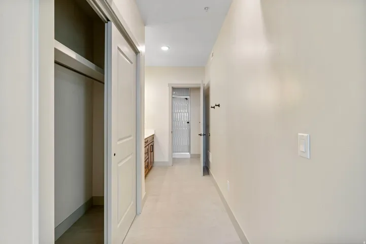 Hallway featuring light neutral wall paint and tile flooring