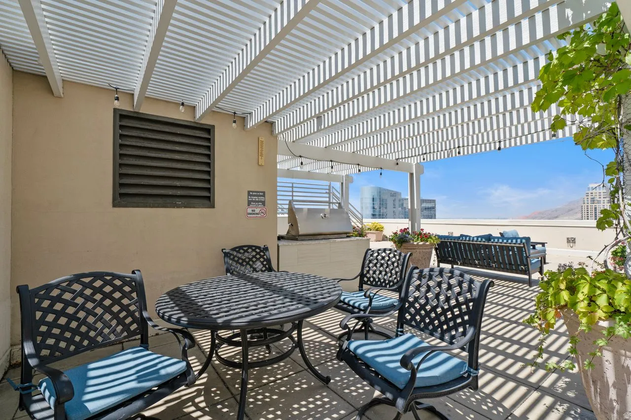 Expansive rooftop patio with a slatted pergola providing partial sun coverage