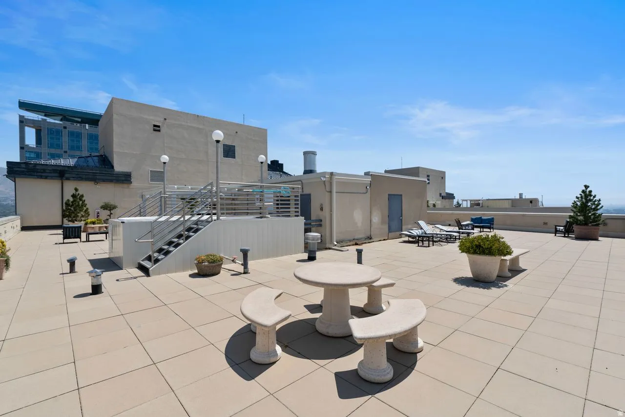 Expansive rooftop terrace featuring large format tile flooring and a built-in stone table with benches