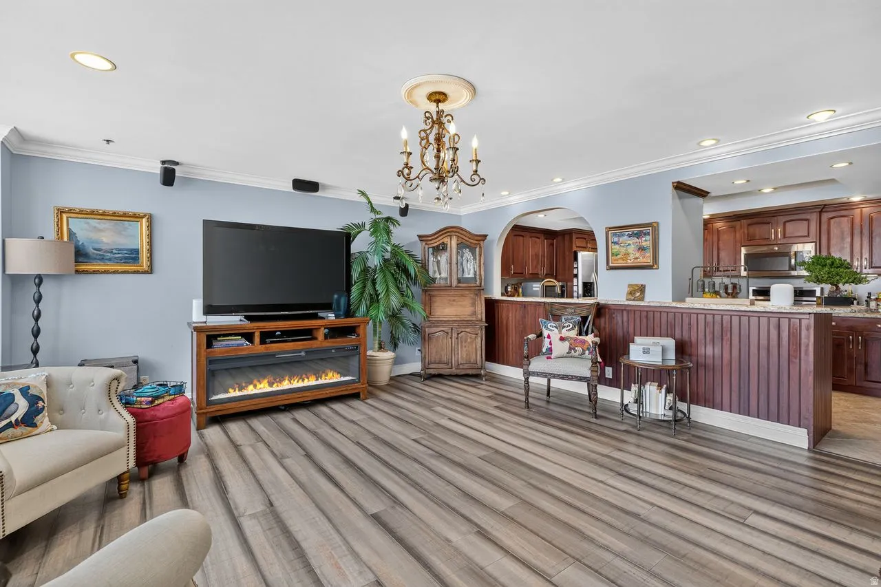 Expansive living space featuring wood-finish flooring, crown molding, and recessed lighting