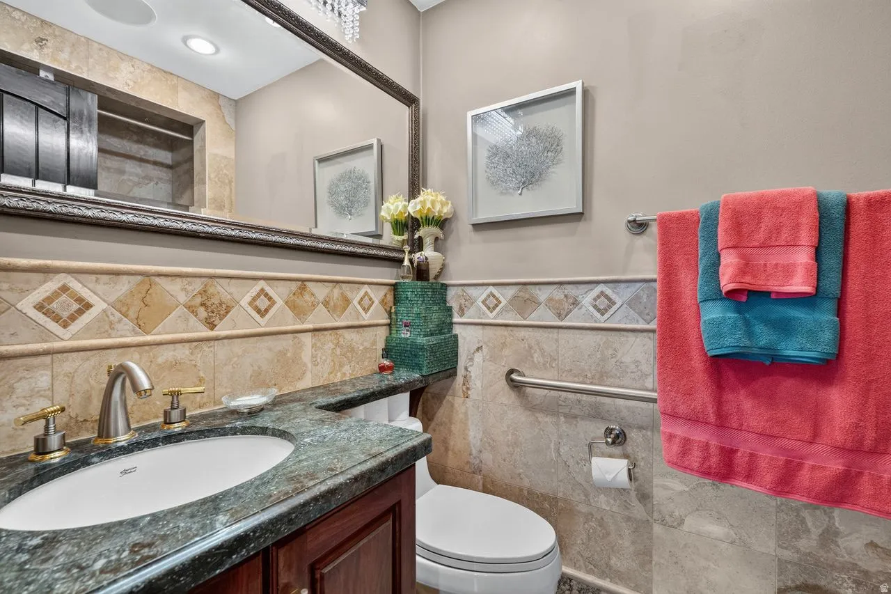 Hardwood vanity with an inset basin, green granite countertop, and brushed nickel and brass-tone faucet