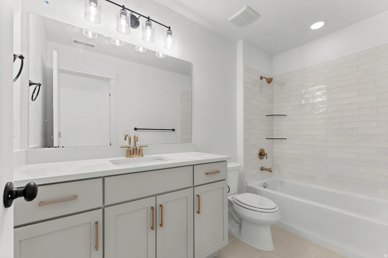 White subway tile shower surround with dual recessed shelves, a built-in tub, and bronze fixtures