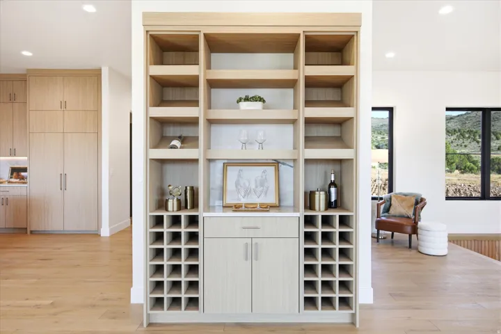 Built-in shelving unit with wood-finish cabinetry, integrated wine storage, and a light-toned countertop