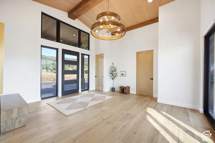 Vaulted wood-paneled ceilings with exposed beams and a large chandelier