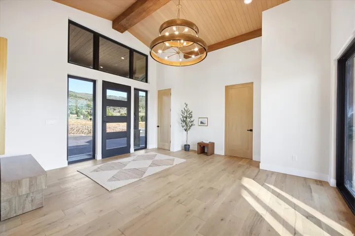 Vaulted wood-paneled ceilings with exposed beams and a large chandelier