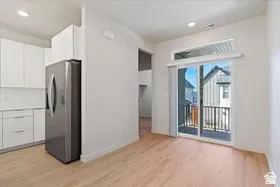 Open-concept living area featuring light wood-finish flooring, white walls, and recessed lighting