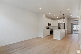 Open-concept living space featuring wood-finish flooring, recessed lighting, and a contemporary kitchen
