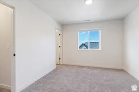 Spacious room featuring light gray carpeting and bright white walls