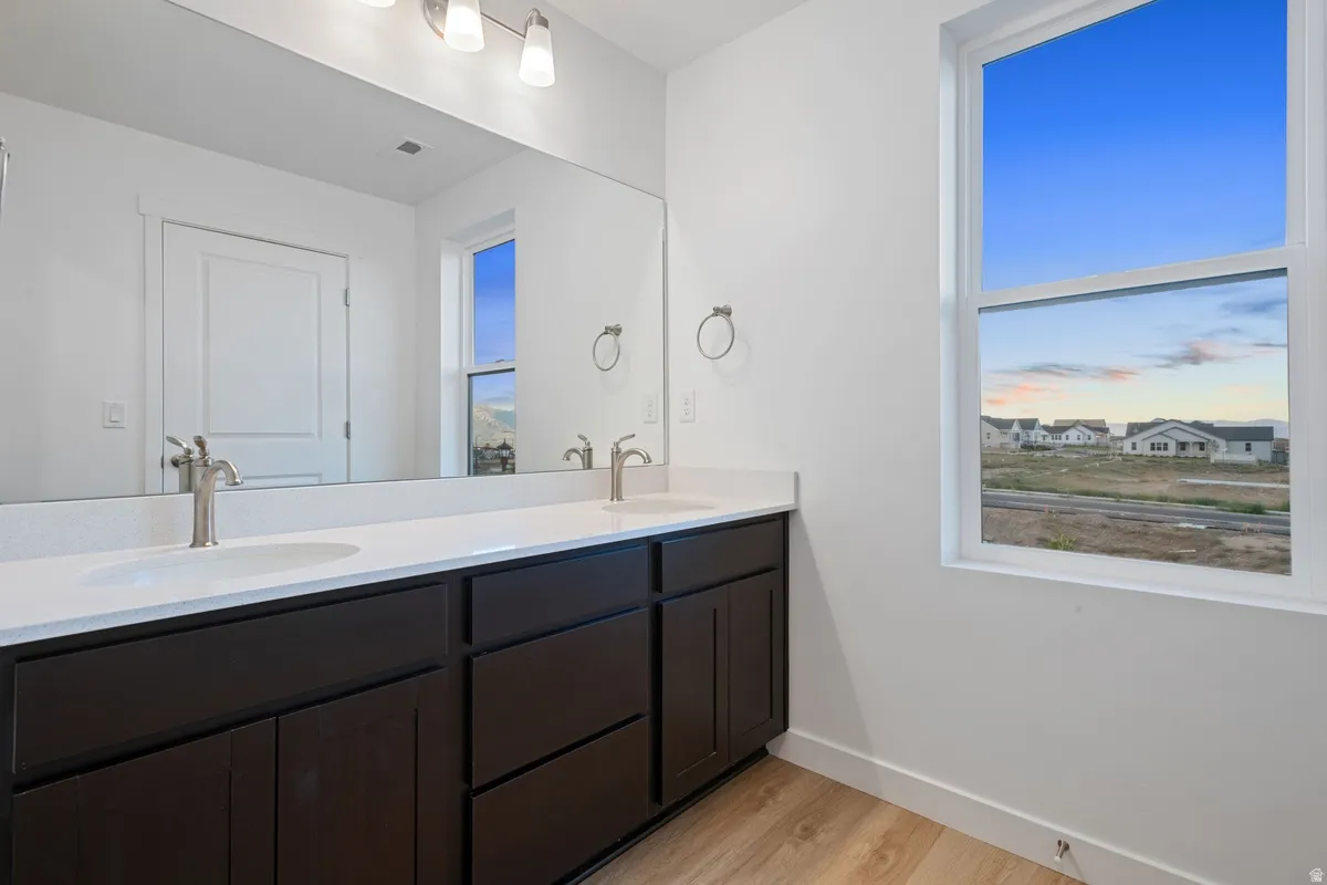 Bathroom featuring a double vanity with dark wood-finish cabinetry, white countertops, and brushed nickel fixtures