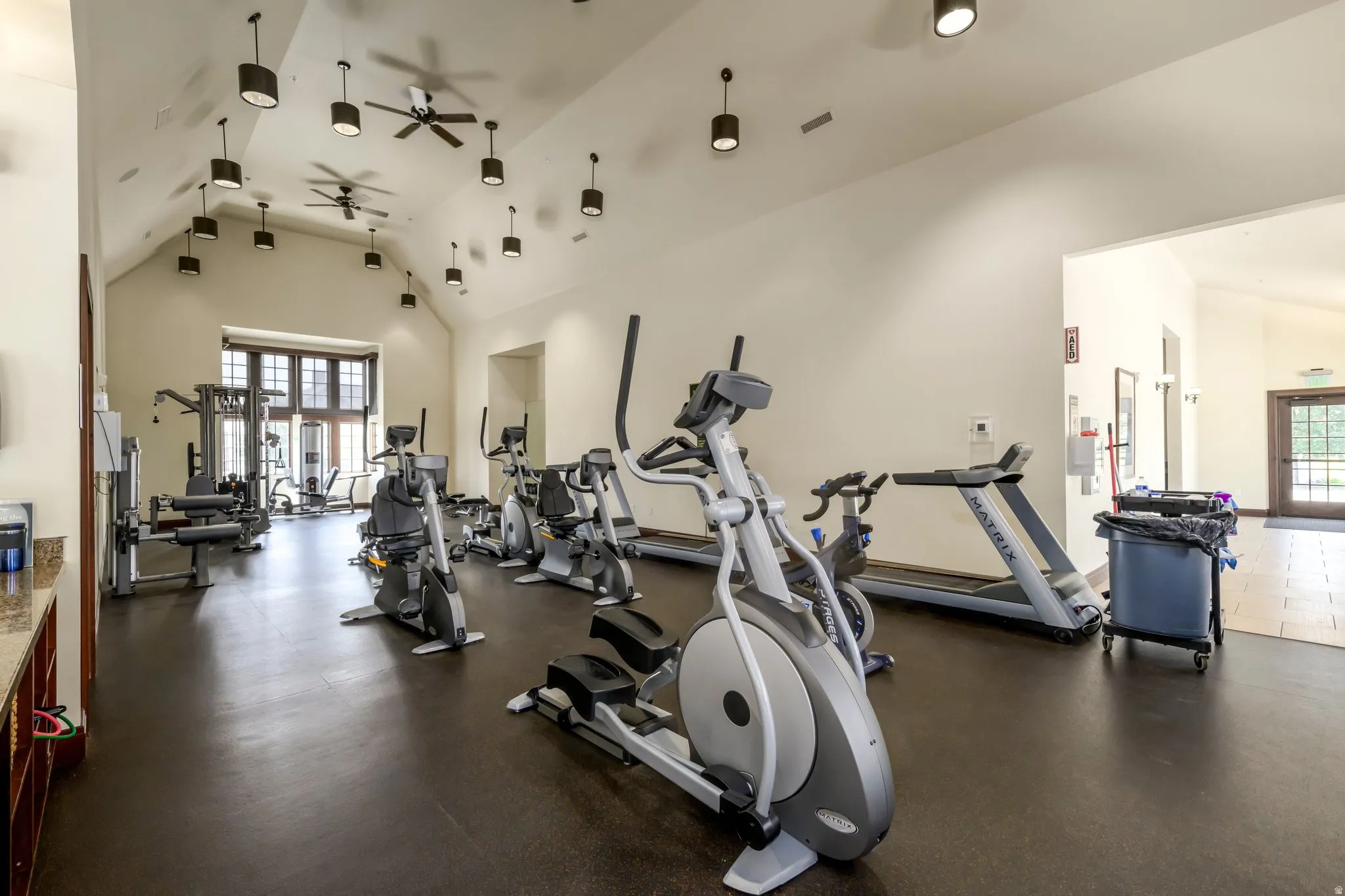 Fitness center with vaulted ceilings, exposed beams, and multiple ceiling fans