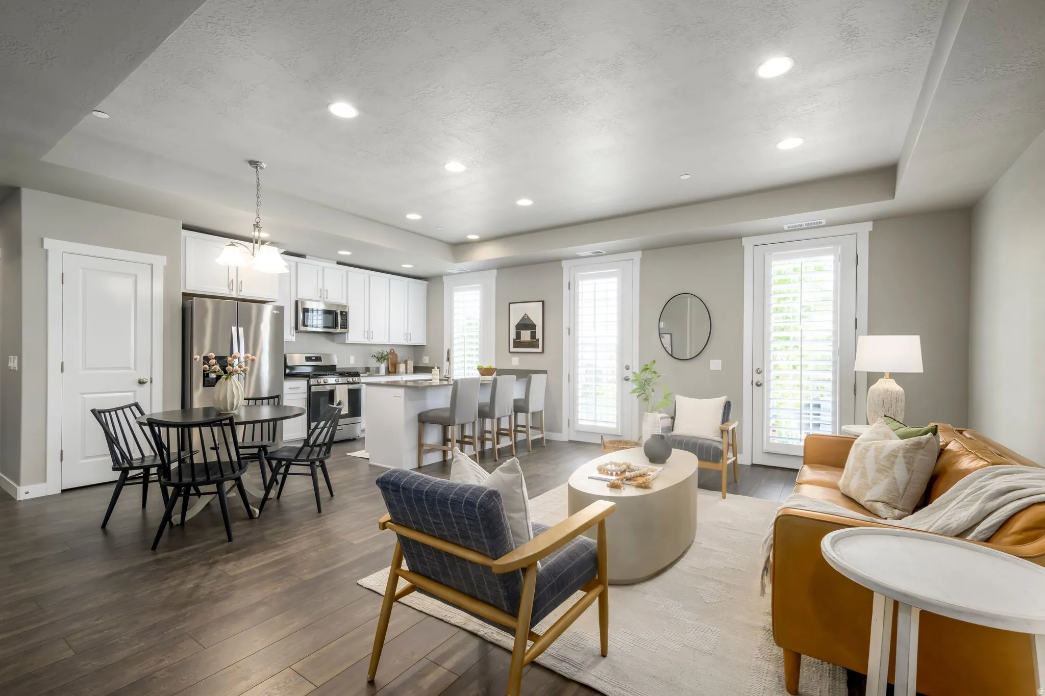 Open-concept living space featuring wood-finish flooring, recessed lighting, and a neutral color palette