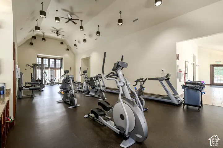 Fitness center with vaulted ceilings, exposed beams, and multiple ceiling fans