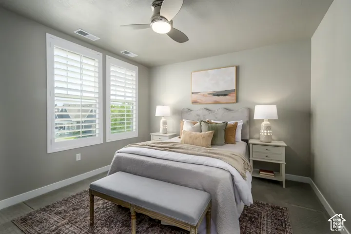 Neutral tone walls with white trim, two windows featuring plantation shutters, and a ceiling fan with integrated lighting