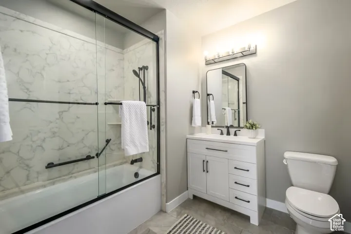 Spa-inspired primary bathroom showcasing a frameless glass-enclosed shower with marble tile surround, white vanity with dual sinks and ample storage drawers, polished chrome fixtures, and soft ambient lighting