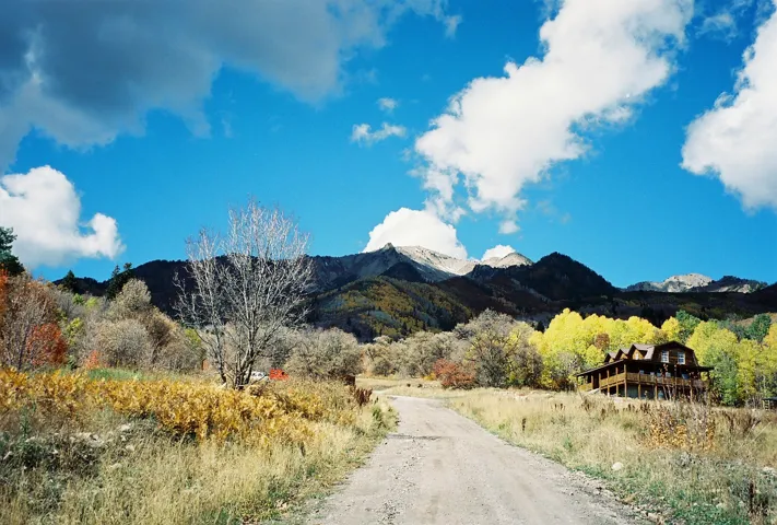 Spacious mountain property featuring a log cabin style residence with multiple balconies and a multi-level roofline in development