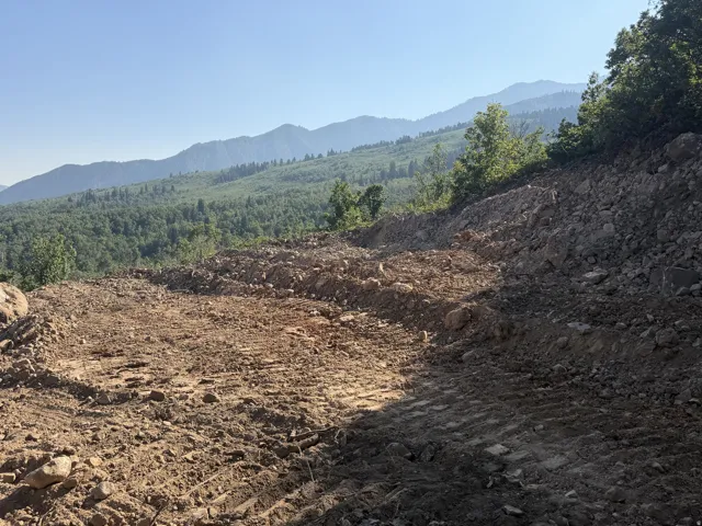 Cleared building pad with mountain and forest scenery