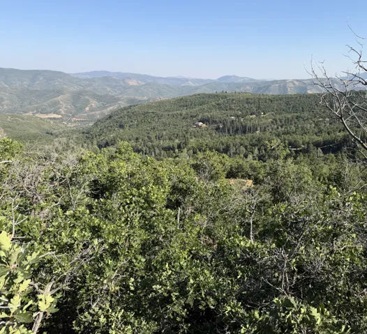 More Expansive mountain landscape views from the lot featuring dense green foliage and distant rolling hills under a clear sky