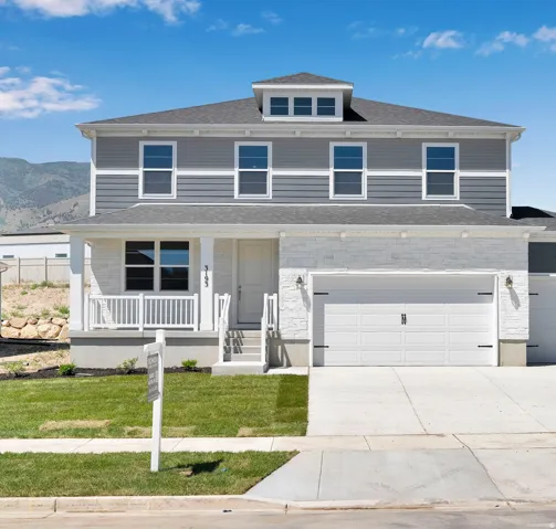 Contemporary two-story residence featuring a gray and white exterior with stone and siding accents