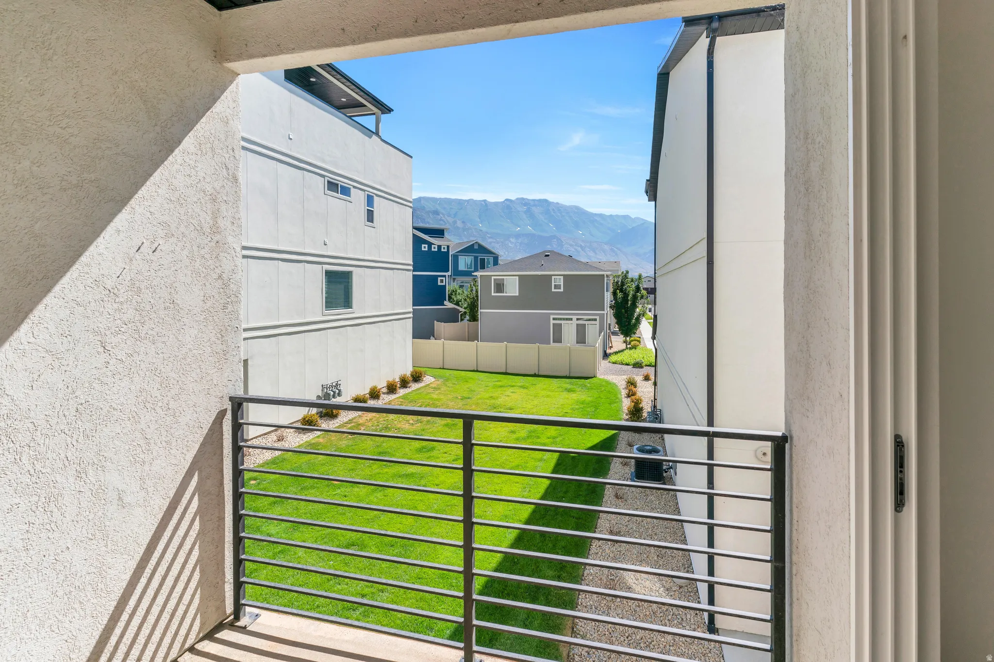 Outdoor balcony with metal railings and a textured exterior wall