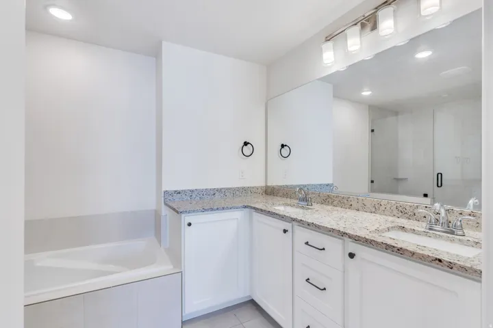 Double vanity with light-toned speckled countertops and undermount sinks