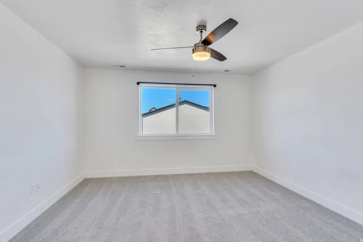 Bright interior space featuring a ceiling fan with integrated lighting