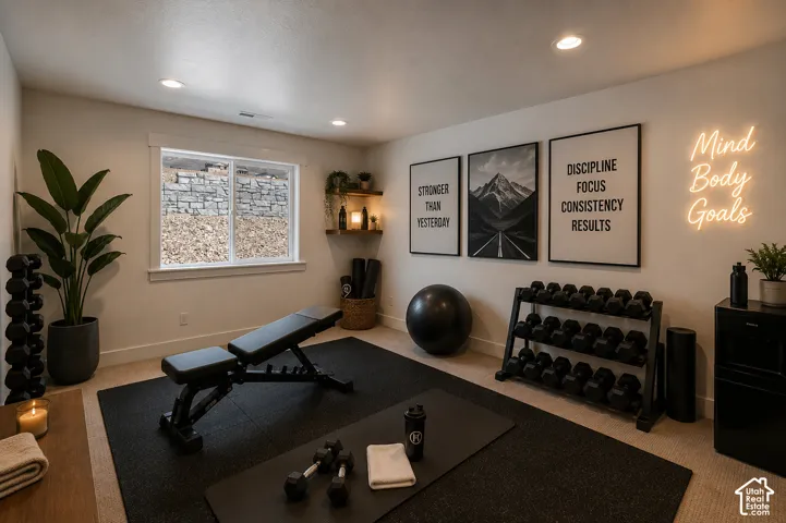 Dedicated fitness space featuring recessed lighting, a built-in window with stone and gravel exterior, wall-mounted floating shelves, and carpeted flooring