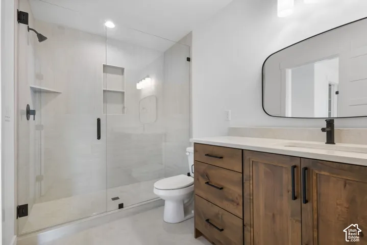 Modern bathroom featuring a wood-finish vanity with a light-toned countertop, an integrated sink, and matte black fixtures
