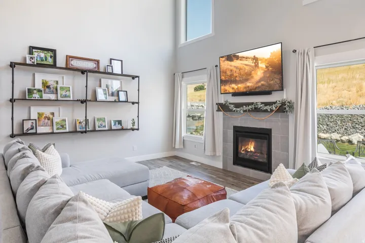 Living area featuring a fireplace with a tile surround, a dark wood mantel, and built-in industrial-style shelving