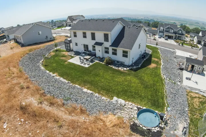 Backyard featuring a green lawn, concrete patio, and an inground circular plunge pool