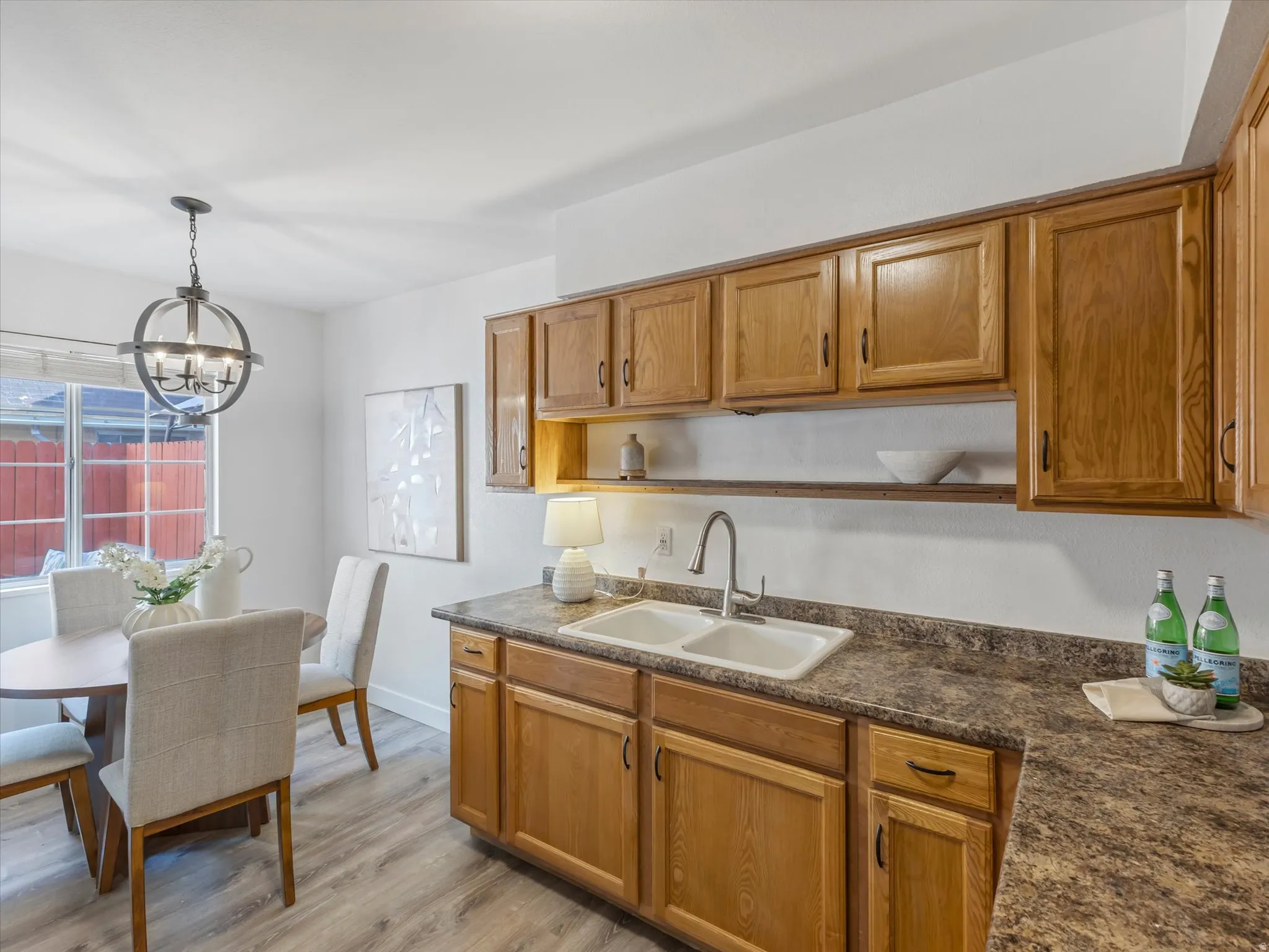 Kitchen area featuring wood-finish cabinetry, a double basin sink, and laminate countertops