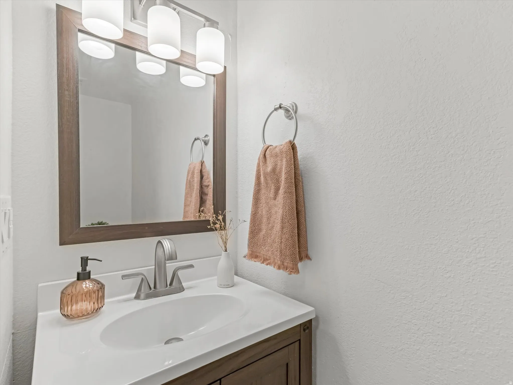 Bathroom vanity featuring a white countertop, undermount sink, and brushed nickel faucet
