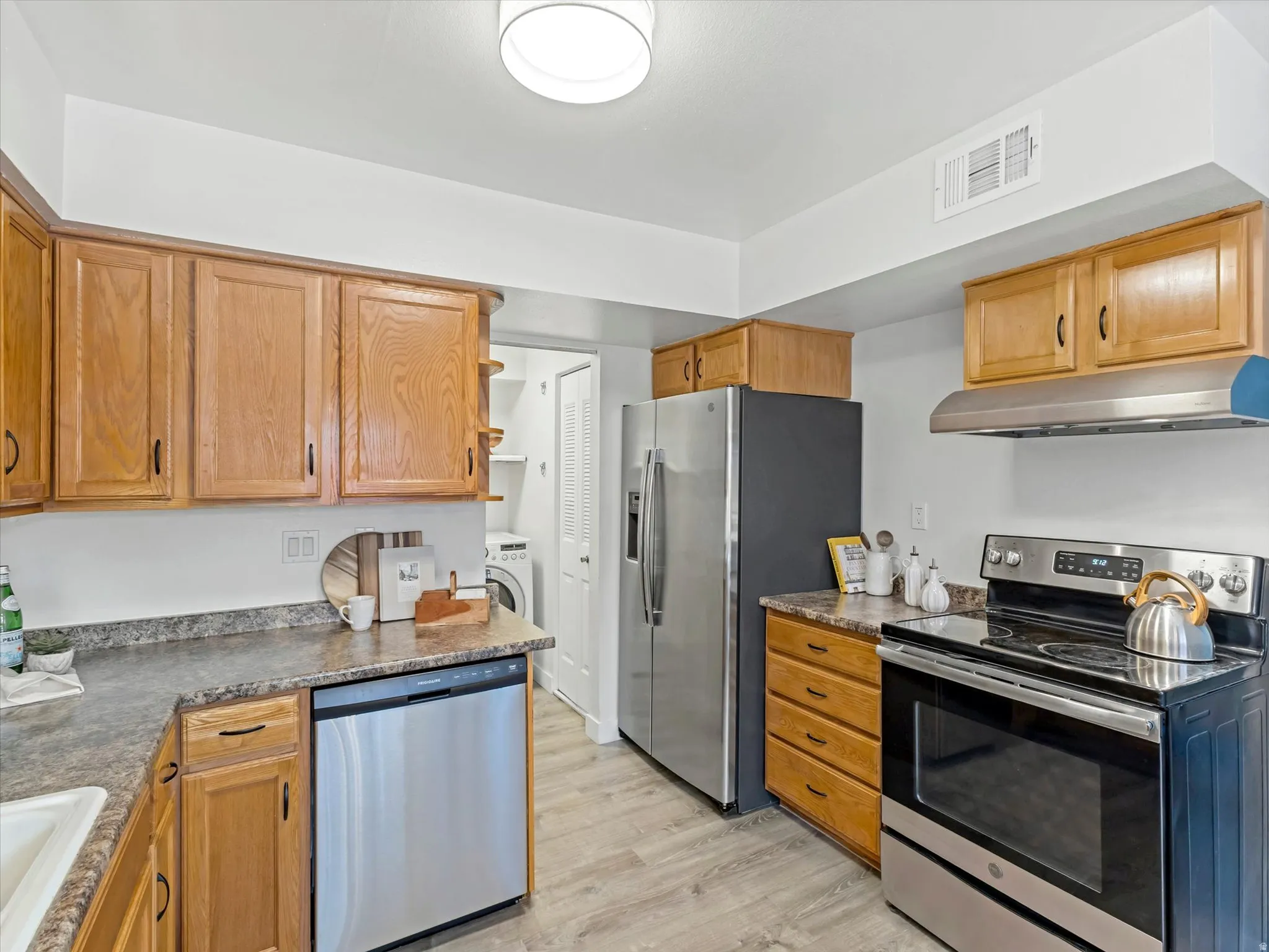 Kitchen featuring wood cabinetry, laminate countertops, and stainless steel appliances