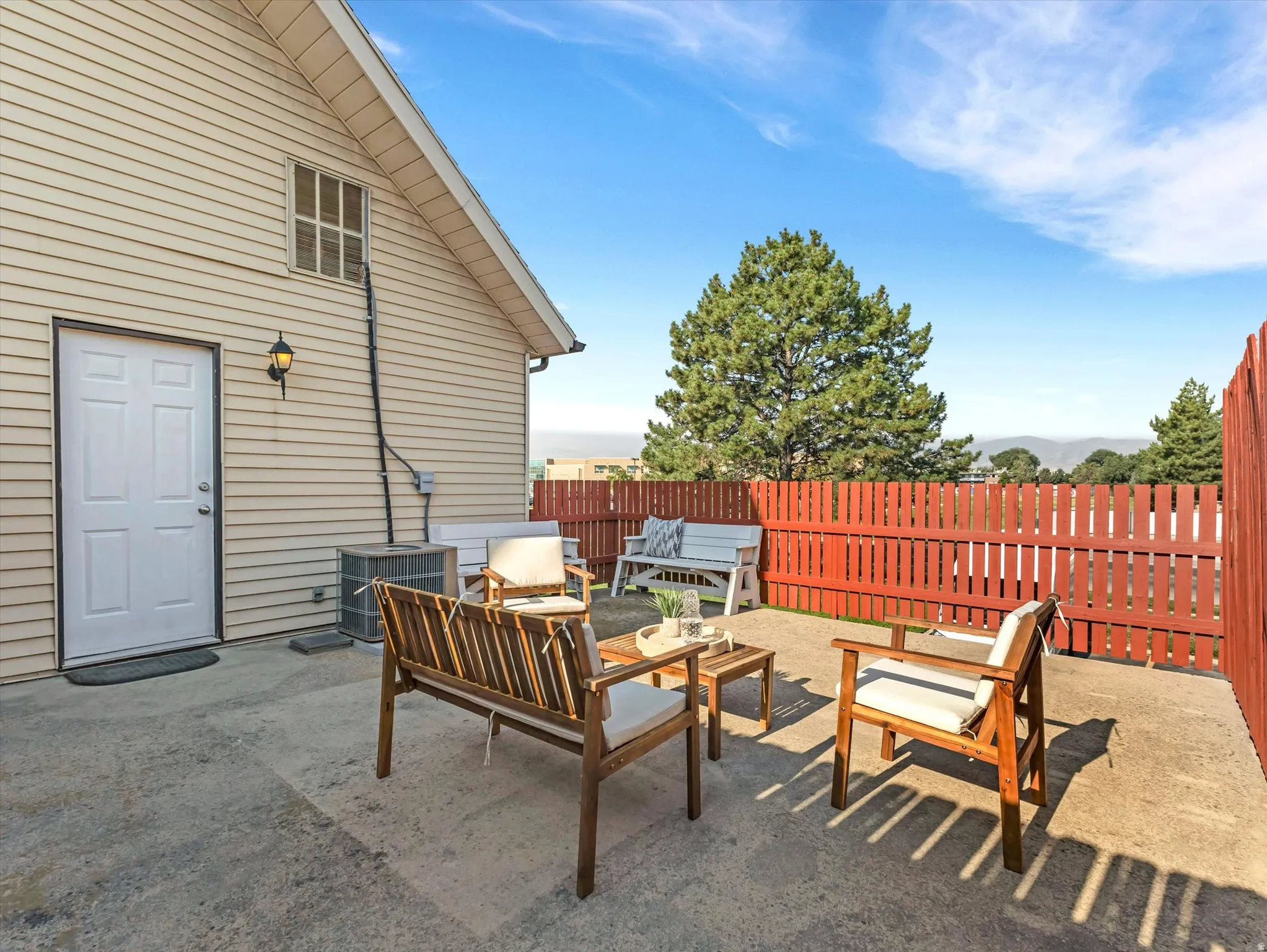 Concrete patio with a red picket fence, offering outdoor space