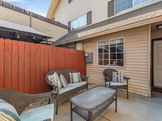 Private concrete patio featuring a reddish-brown privacy fence