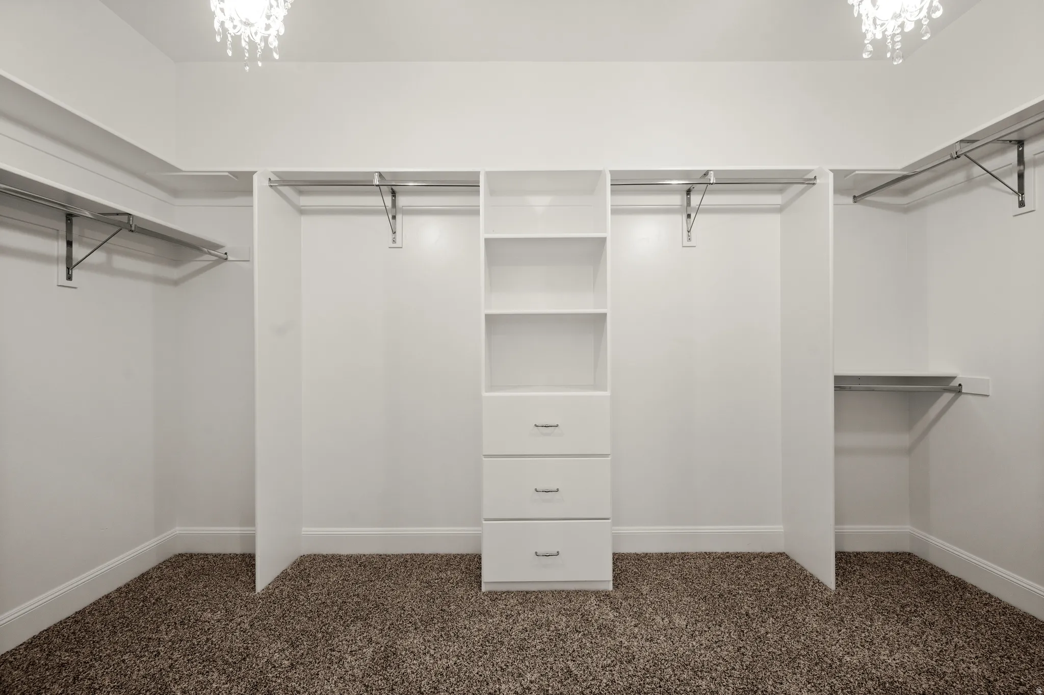 Walk-in closet featuring built-in shelving, hanging rods, and integrated drawers
