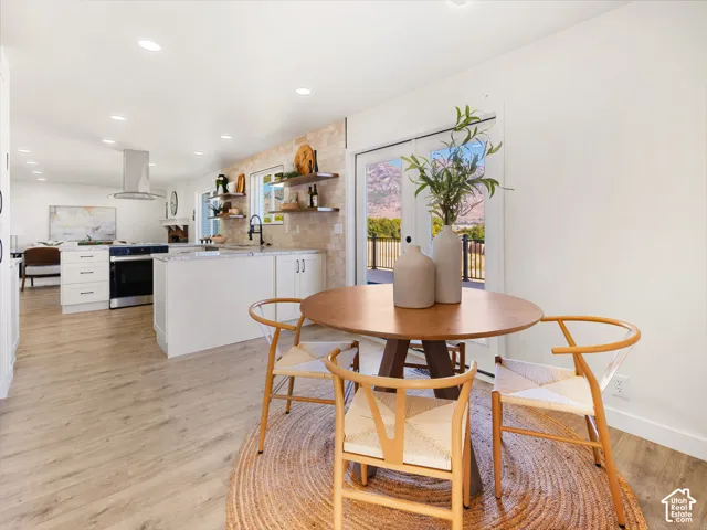 Open-concept living space featuring wood-finish flooring, recessed lighting, and white cabinetry