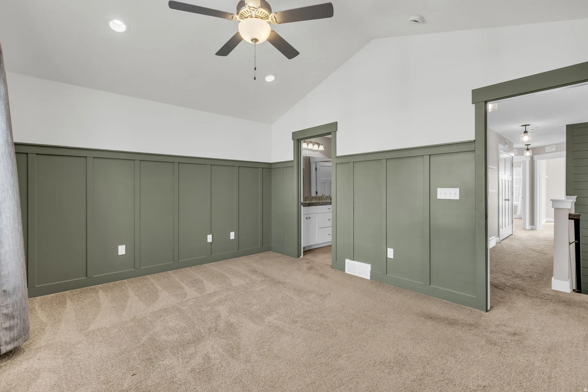 Vaulted ceiling room featuring wainscoting accent walls, recessed lighting, and a ceiling fan