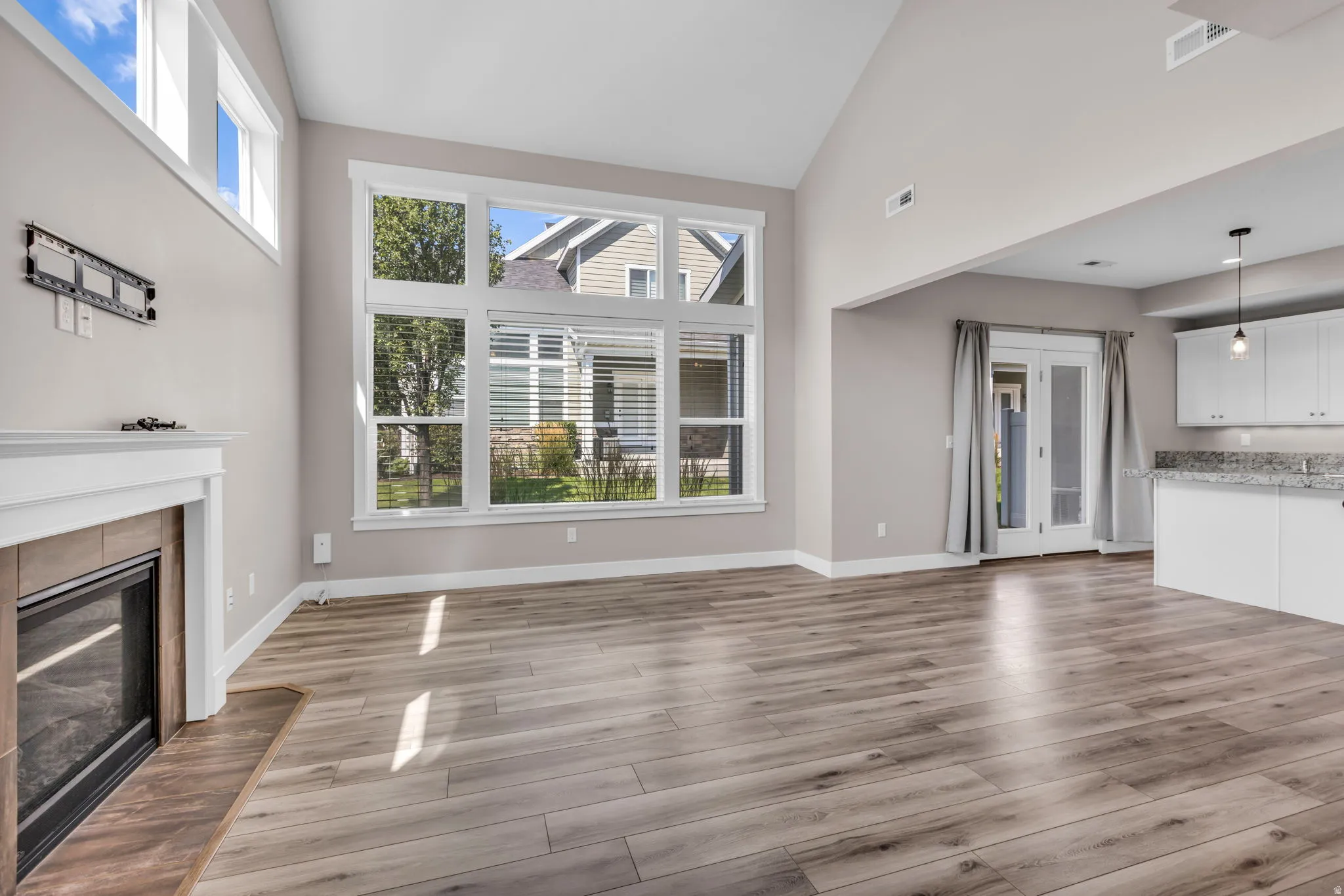 Expansive living area featuring vaulted ceilings and wood-finish flooring