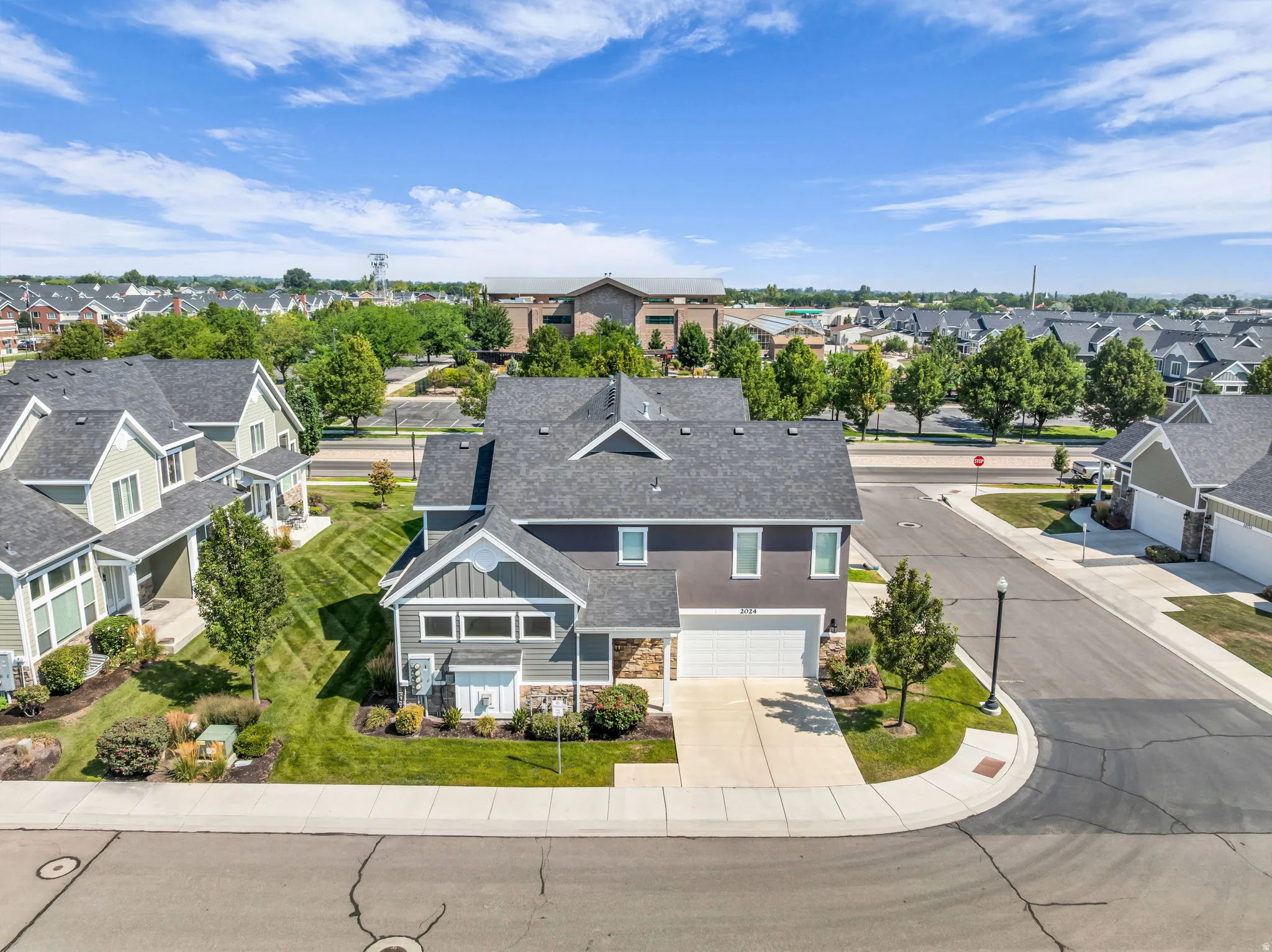 Contemporary two-story residence featuring a dark gray exterior with stone accents and white trim