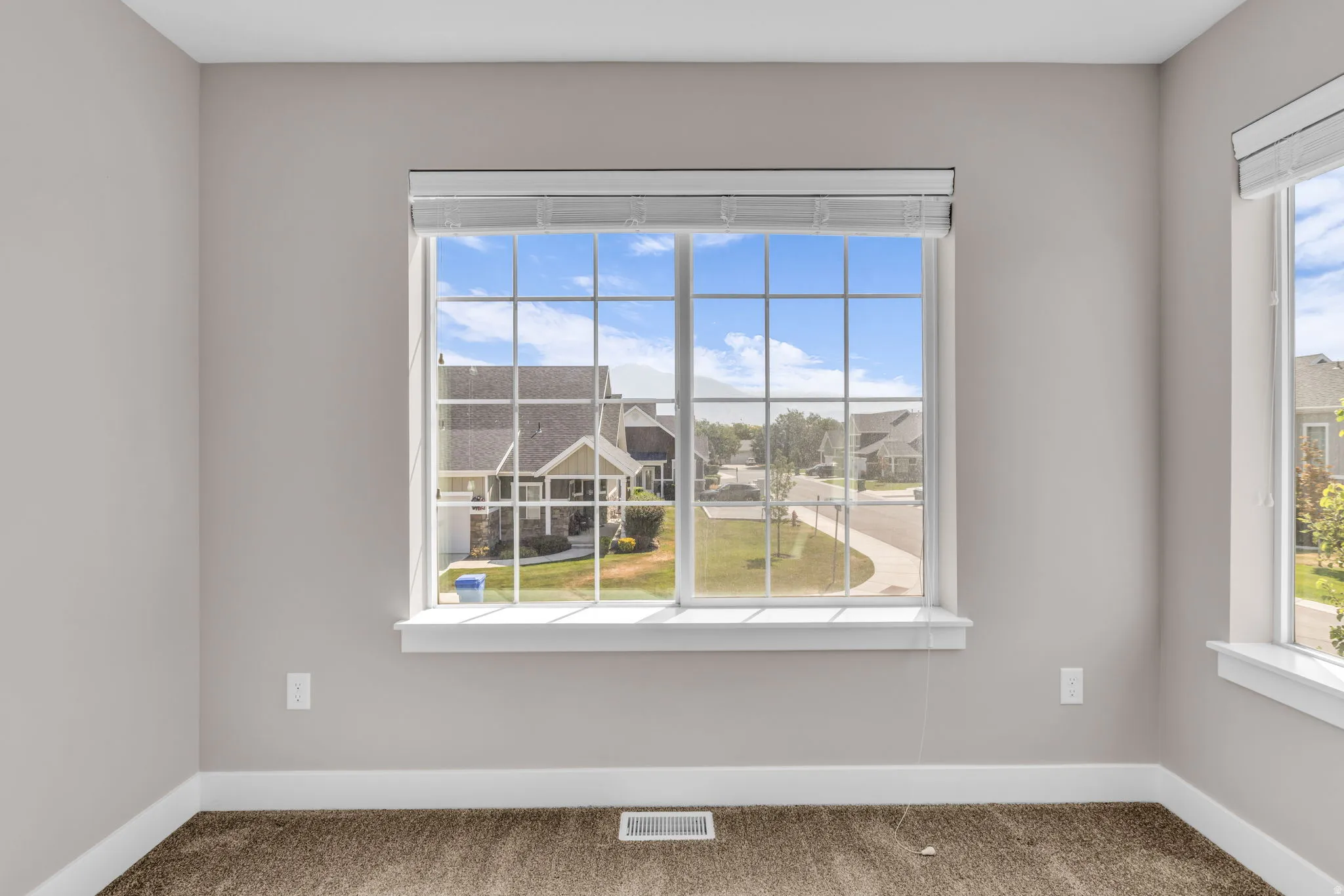 Expansive window with white grilles and integrated blinds