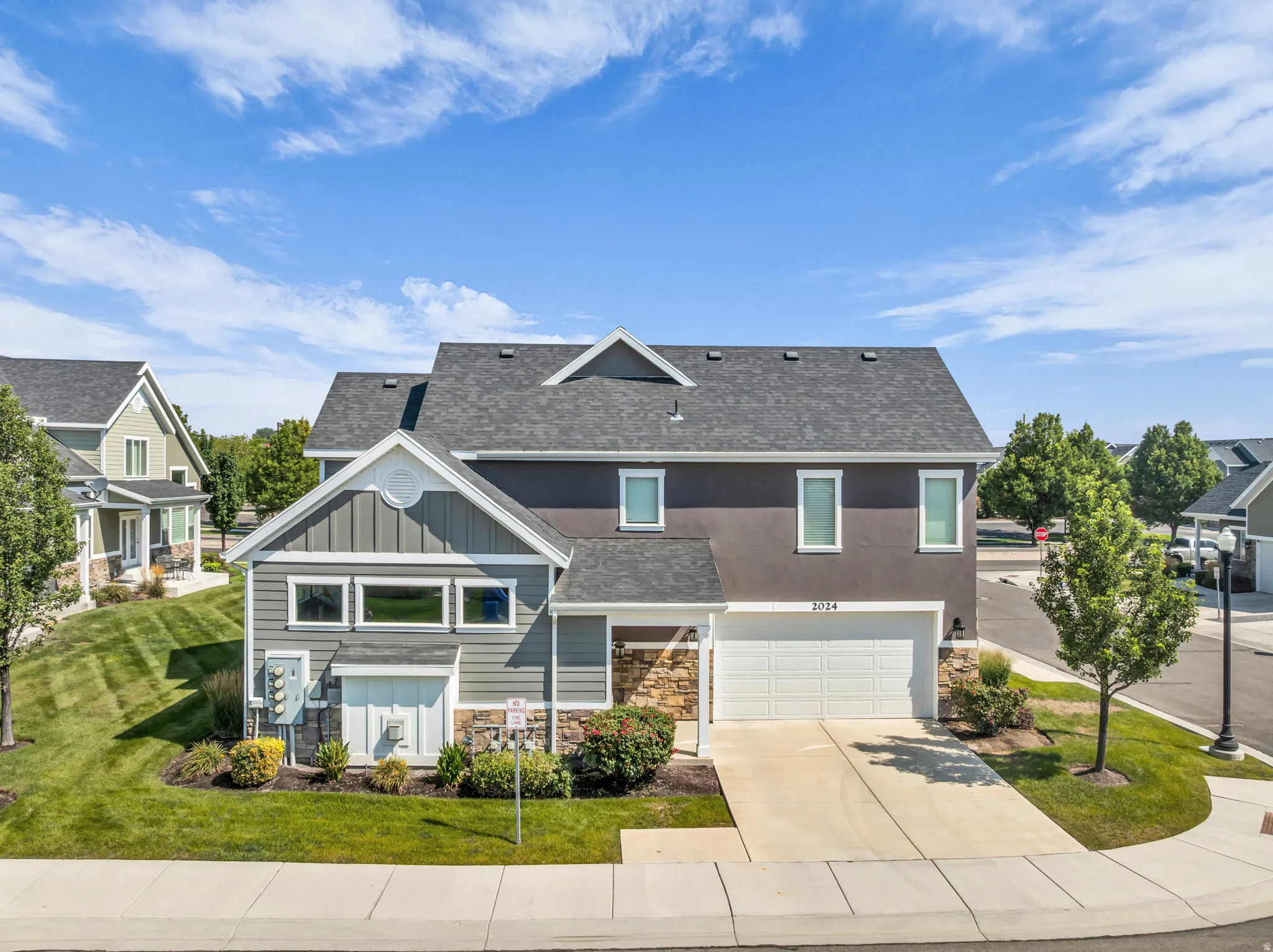 Contemporary-style residence featuring a two-car garage, stone accents, and varied siding textures