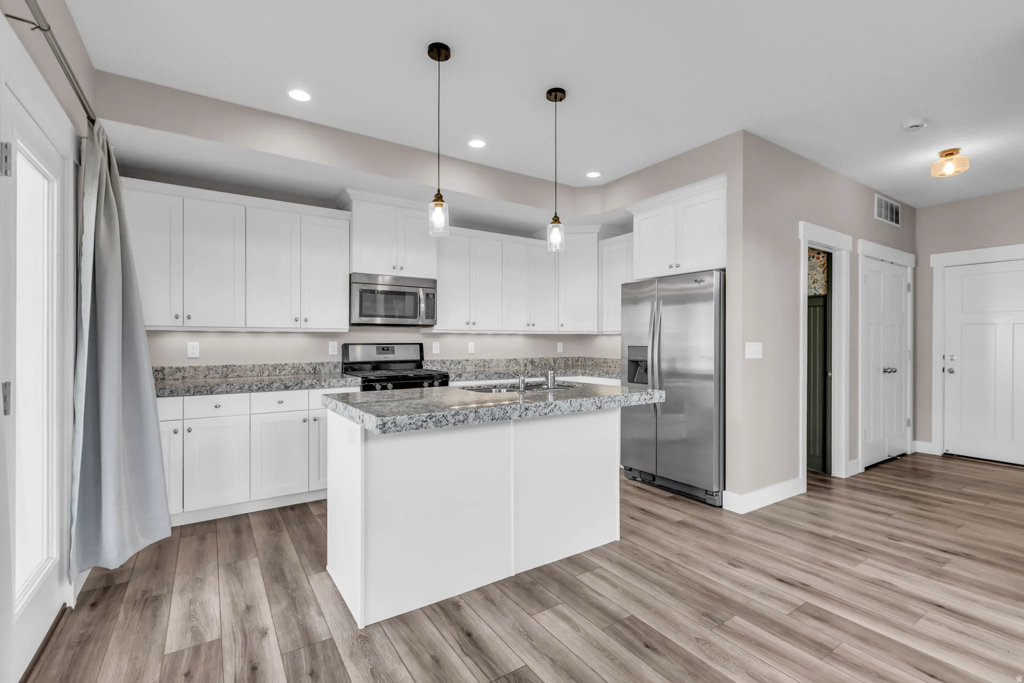 Modern kitchen with extensive white cabinetry and stainless steel appliances