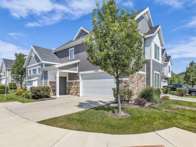 Contemporary townhouse exterior featuring a mix of gray siding, stucco, and stone accents