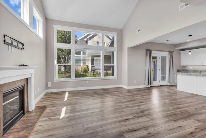 Expansive living area featuring vaulted ceilings and wood-finish flooring