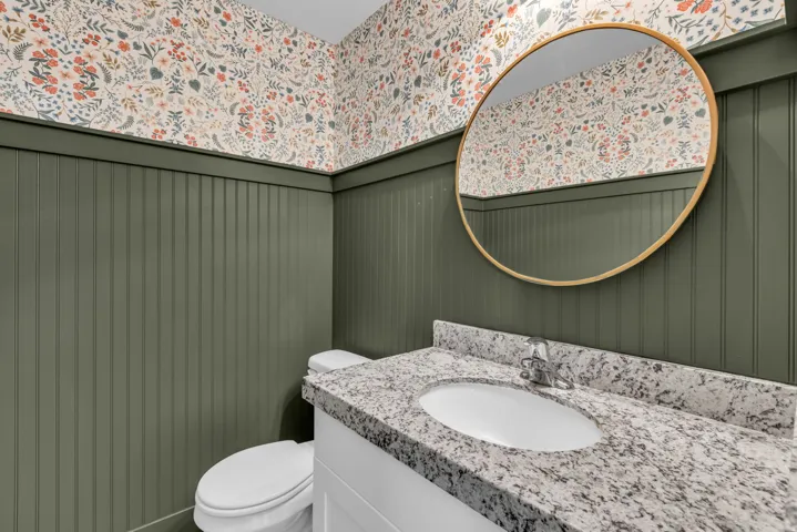 Vanity featuring a white undermount sink, speckled countertop, and chrome faucet