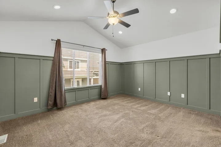 Vaulted ceilings with recessed lighting and a ceiling fan